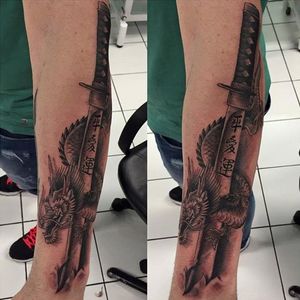 Black and grey Katana breaking in the skin, wrapped by the dragon! by Samuel Pujades #katanatattoo #dragon #samuealpujades