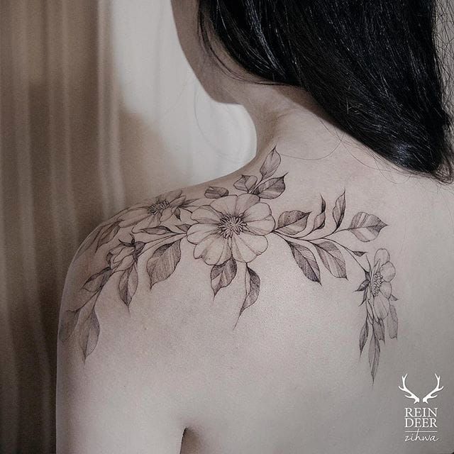 Fine line flower bouquet tattoo on the upper arm