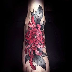Amazingly clean and detailed chrysanthemum tattoo on a foot. Tattoo by Alexander Mosom. #alexandermosom #foottattoo #chrysanthemum #flowertattoo #blackandred
