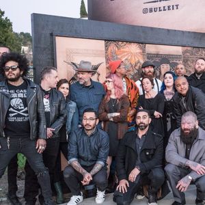 The artists posing outside of the Bulleit Frontier Whiskey tattoo billboard. Photo by Elizabeth Dixon