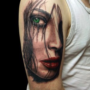 Incredible use of minimal color in just the right places. Tattoo by Steve Toth. #SteveToth #BritishTattooer #blackandgrey #realism #hyperrealism #MonumentalInk #redlips #greeneye #woman