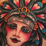 Blue Eyed Lady tattoo by Samuele Briganti #samuelebriganti #portraittattoos #color #traditional #ladyhead #lady #eyes #headdress #nativeamerican #feathers #jewelry #crown #pattern #tattoooftheday