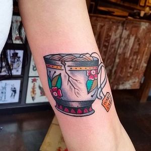 Beautful tea cup tattoo with blossoms by Douglas Grady. #DouglasGrady #traditionaltattoo #coloredtattoo #brightandbold #cup #teacup