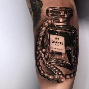 Chanel tattoo by Christos Galiropoulos #ChristosGaliropoulos #fashiontattoo #blackandgrey #realism #realistic #hyperrealism #glass #perfume #pearls #perfumebottle #bottle #Chanel #fashion #style #tattoooftheday