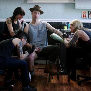 Andy Suzuki being tattooed by Ashley Love, Tron, and Amy Shapiro for the "Lucy" video.
