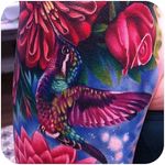 Details on this colorful tattoo of a humingbird and flowers by Megan Massacre @megan_massacre #tattoodo #color #colorful #realistic #humingbird #flowers #megan_massacre