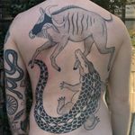 Example of the circle of life tattoo by Jenna Bouma aka Slowerblack #JennaBouma #Slowerblack #handpoketattoos #backpiece #crocodile #waterbuffalo #animal #fight #versus #naturalselection #nonelectric #stickandpoke