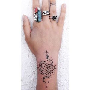 A charming snake tattoo by Tati Compton (IG—taticompton). #blacktattoo #handpoked #TatiCompton #wristtattoo
