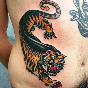 Awesome crawling tiger tattoo on the side. Great tattoo work by Alex WIld! #AlexWild #traditionaltattoo #boldtattoos #tiger #crawlingtiger