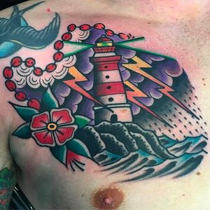 Super clean and vibrant lighthouse chest tattoo by Filip Henningsson. #FilipHenningsson #RedDragonTattoo #traditionaltattoo #boldtattoos #lighthouse