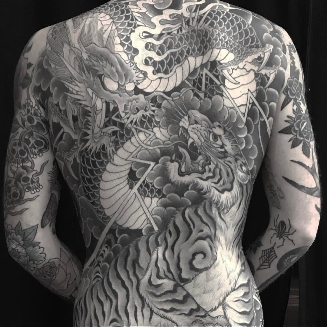 Tattoo uploaded by Tattoodo • Dragon versus Tiger tattoo by Chris Garver #ChrisGarver #dragontattoos #Japanese #blackandgrey #dragon #tiger #junglecat #scales #fire #lightning #clouds #fight #battle #warrior • Tattoodo