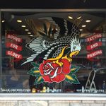 An eagle perched on a rose painted by Tina Fino on Bound for Glory's front window (IG—tina_fino). #BoundforGlory #eagle #rose #signpainting #tattooinspired #TinaFino