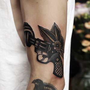 A revolver with a knotted snout. Cool concept and tattoo done by Ibi Rothe. #IbiRothe #traditionaltattoo #boldtattoos #gun #blossom
