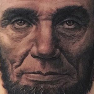 A close up shot of an Abe Lincoln portrait tattooed by Steve Wimmer. #SteveWimmer #portraittattoo #realistic #AbrahamLincoln #blackandgrey