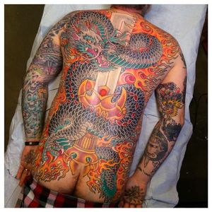 Intense dragon back tattoo with a sword and flames. Tattoo done by Jason Brooks. #JasonBrooks #GreatWaveTattoo #boldtattoos #TraditionalTattoo #dragon #ryu #sword #flames