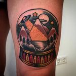 UFO in the mountains in a snow globe tattoo by Augusto Rodriguez. #snowglobe #glass #UFO #mountain #traditional