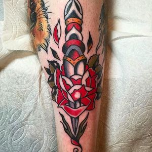 Another awesome dagger through the rose tattoo by Jacob N. #JacobN #traditionaltattoo #boldtattoo #oldschool  #dagger #rose #traditional