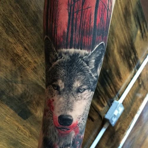 Blood is in the air in this depiction of a wolf on the hung by Ash Higham (IG—ashhighamtattoos). #animals #AshHigham #blackandgrey #blood #color #forest #realism #wolf