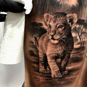 Lion cub tattoo by Sergio Fernandez #SergioFernandez #whiteinktattoos #blackandgrey #realism #realistic #illustrative #painterly #lioncub #lion #babyanimal #animal #nature #trees #africa #giraffe #safari #tattoooftheday