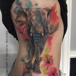Vibrant elephant and flower watercolor tattoo by Danielle Merricks. #flower #elephant #watercolor #inksplatter #DanielleMerricks