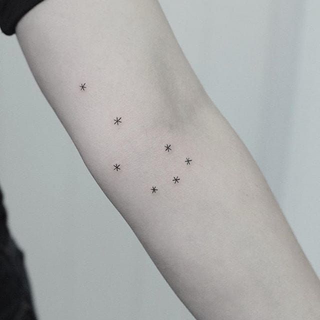 Minimalistic stars tattooed on the elbow
