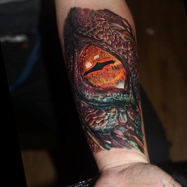 Black and grey reptile eye tattoo on the left side