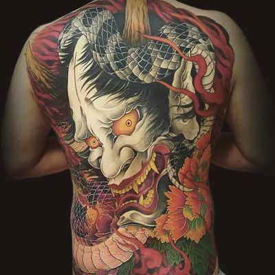 The Oni rears his head by Hajin Irezumi #HajinIrezumi #japanese #newtraditional #mashup #color #Onimask #oni #snake #leaves #fire #smoke #fangs #scales #backpiece #tattoooftheday