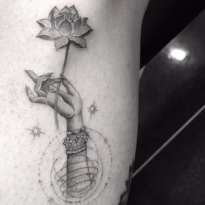 Tiny hand holding a tiny lotus by Doctor Woo #DoctorWoo #blackandgrey #linework #small #dotwork #minimal #lotus #mudra #jewelry #stars #Buddhism #enlightenment #geometric #tattoooftheday
