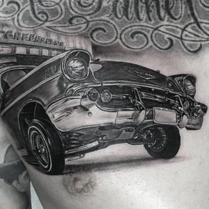 Lowrider Chevy tattoo by Chuey Quintanar #ChueyQuintanar #cartattoos #blackandgrey #realism #realistic #hyperrealism #car #chevy #chevrolet #50s #tires #lights #chrome #metal #tattoooftheday
