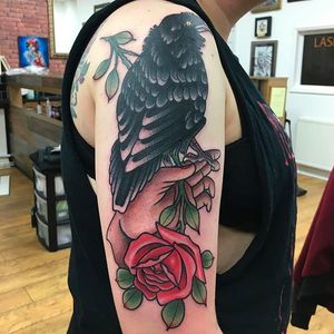 A crow tattoo perched on a hand with a rose. Amazing work by Dan Hartley. #DanHartley #TripleSixStudios #NeoTraditional #crow #hand #rose