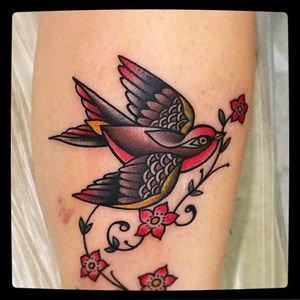 Swallow bird and blossoms Tattoo by @Capratattoo #Capratattoo #traditional #black #red #SkullfieldTattoo #swallow #bird #blossoms