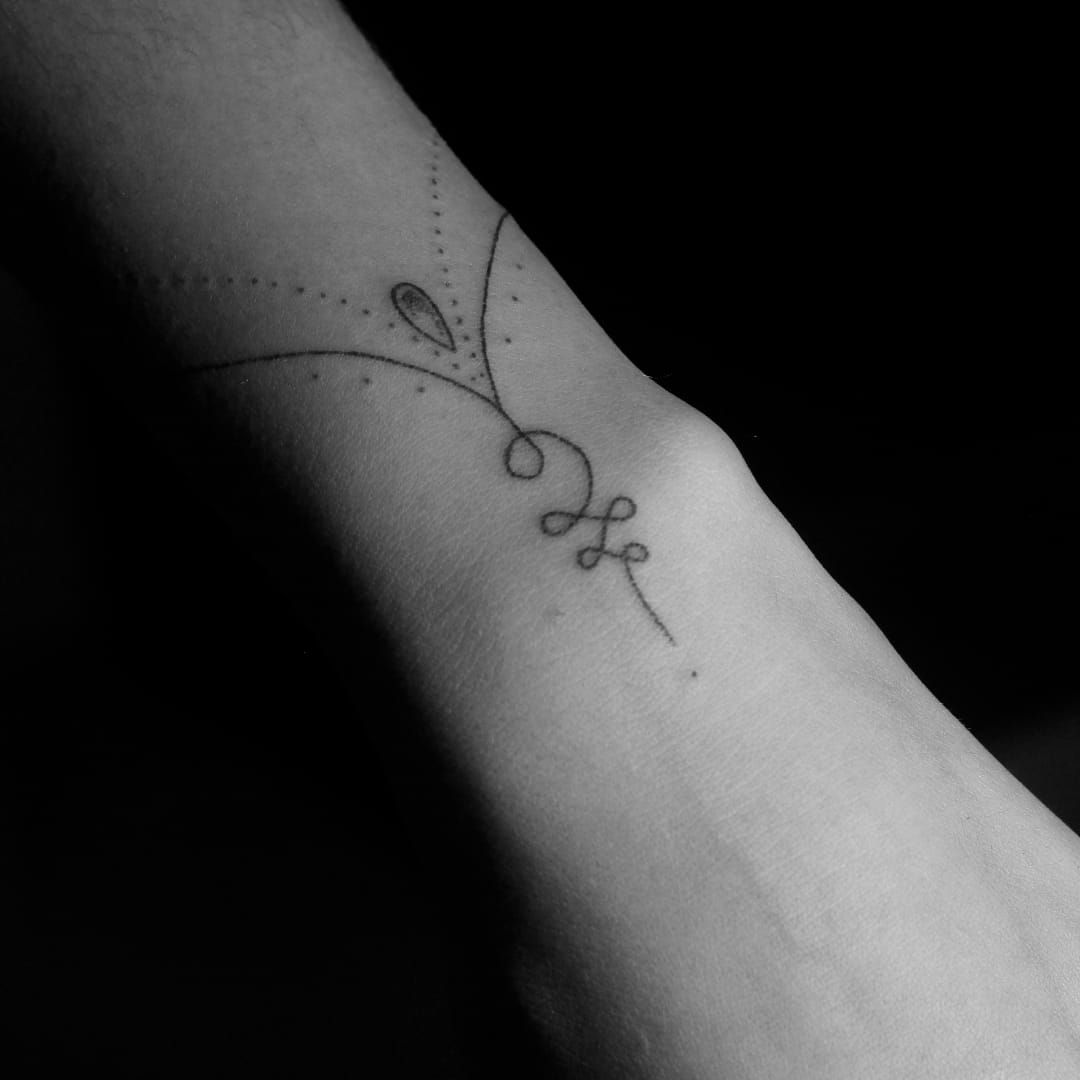 Tiny sprout tattoo on the left forearm