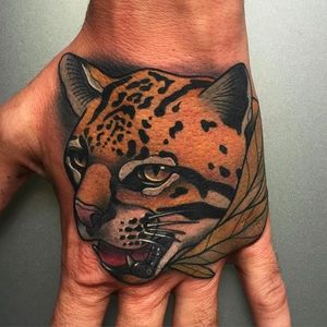 Super clean and solid leopard head tattoo on the hand. Tattoo by Kike Esteras. #KikeEsteras #leopard #animaltattoo #handtattoo #neotraditionaltattoo #animaltattoos