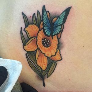 A blue butterfly landing on a daffodil. Tattoo by Alex Gardner. #daffodil #butterfly #traditional #neotraditional #flower #AlexGardner