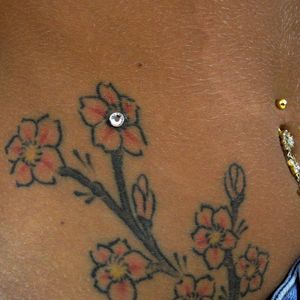 Give life to an old tattoo by adorning it with a piercing! #pierced #tattoo #flowers