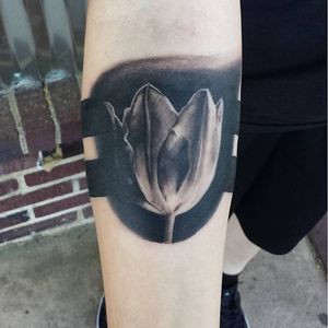 Bold black and grey realistic tulip tattoo by Tyler Wood. #flower #tulip #realism #blackandgrey #TylerWood