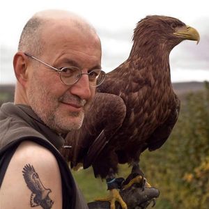 A photo by Andrew Firth of a tattooed bird trainer holding a White Tailed Eagle.  #birdtrainer #eagle #traditional