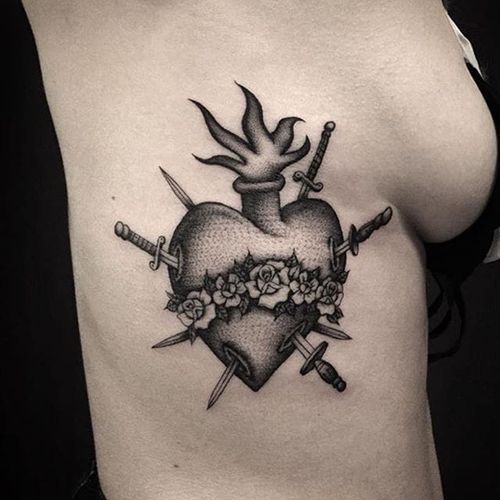 Heart tattoo with fire and knives by @nolc #Sacredheart #SacredHeartTattoo #BlackworkSacredheart #BlackworkTattoos #BlackworkTattoo #Blackwork #knife #heart #fire #roses