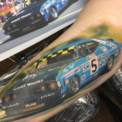 Racing car tattoo by Mitch Goldsbrough #MitchGoldsbrough #cartattoos #color #realism #realistic #hyperrealism #car #musclecar #racing #logos #racecar #ford #falcon #vintage #tattoooftheday