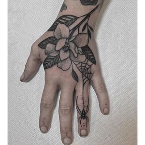 An interesting dotwork magnolia and spider hand tattoo by Justin Olivier. #dotwork #blackwork #spider #magnolia #flower #JustinOlivier