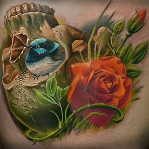 A cute, chubby little bird nestled in an upturned skull. Tattoo by Frederick Bain #FrederickBain #realism #colorrealism #skull #rose #bird