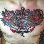 An anchor surrounded by a tiger's head and red roses by Chuck Donoghue (IG—chuckdtattoos). #anchor #ChuckDonoghue #roses #tiger #traditional