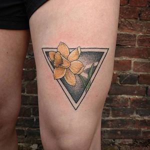 A mixture of styles with a colored daffodil and black dotwork triangle background. Tattoo by Jessi Cramer. #daffodil #flower #dotwork #neotraditional #JessiCramer