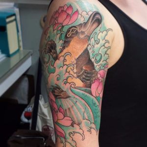 A Japanese styled sleeve tattoo with a platypus swimming through the waves. Tattoo by Krysten Dae. #platypus #monotreme #australiananimal #japanese #flower #waves #KrsytenDae