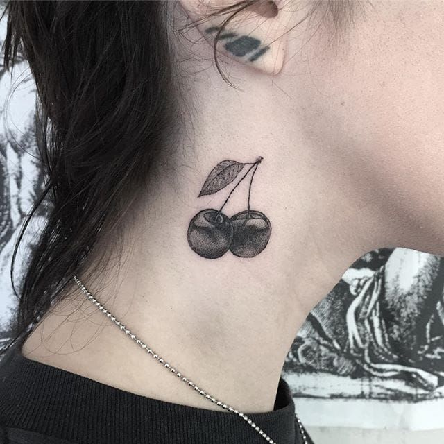 Fine line cherry tattoo on the bicep
