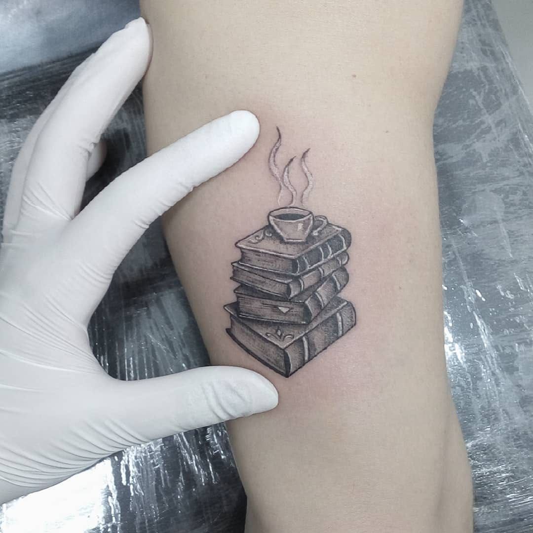 Three books and a coffee cup tattoo on the ankle