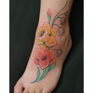 No black outlines here - it's all color. Dainty daffodil foot tattoo by Will Bodnar. #daffodil #flower #WillBodnar #feminine #foot #pastel