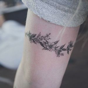 Floral arm bracelet tattoo by Baam. #Baam #TattooerBaam #subtle #microtattoo #southkorean #fineline #bracelet #armband #floral #flower