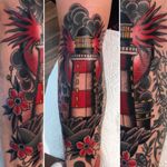 A fiery lighthouse surrounded by flowers by John Spring (IG—johnspringtattoo). #flowers #JohnSpring #lighthouse #seascape #traditional