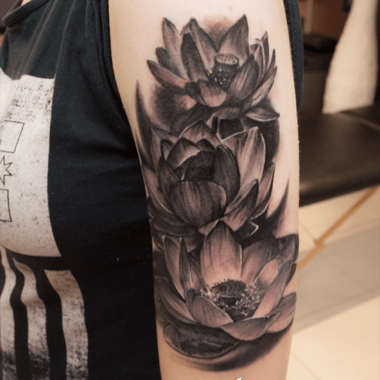 Realistic lotus flower tattoo on the left shoulder